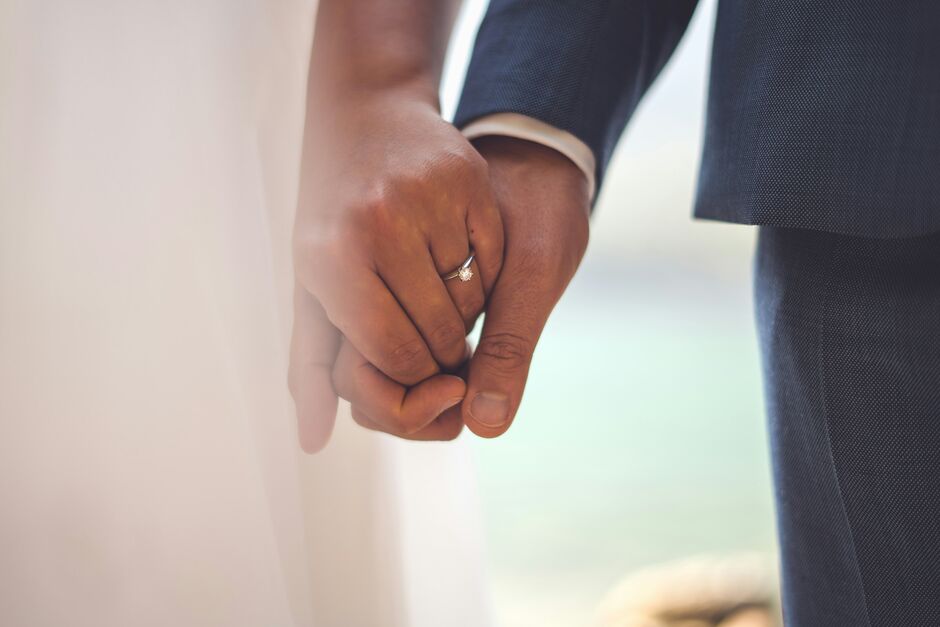 Hände von Eheleuten mit Ringen